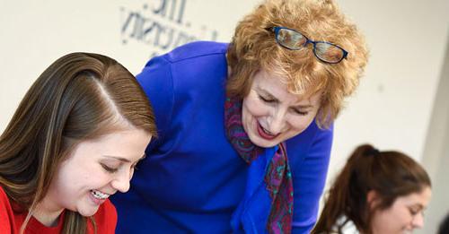 A College Credit Plus student at The University of Akron talks with a faculty member about an assignment